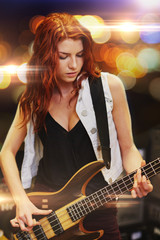 Obraz premium red haired woman playing guitar on stage