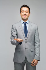 happy businessman in suit showing empty palms