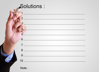 businessman writing solution list with note