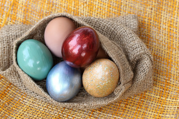 Obraz na płótnie Canvas Colorful easter eggs in burlap hessian sacking bag.