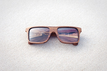 double exposure of wooden sunglasses  and desert road