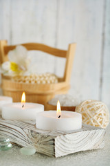 Fototapeta na wymiar Candles and bucket with spa treatment on wooden background