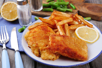 Breaded fried fish fillets and potatoes with asparagus and