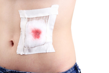 Injured abdomen with adhesive bandage isolated on white