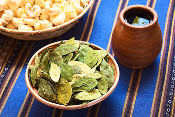 Dried coca leaves in clay bowl with fresh coca tea