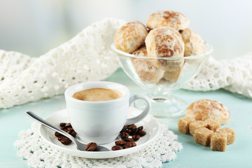 Cup of coffee and tasty cookie on color wooden background