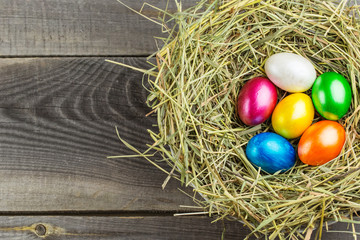 Fototapeta na wymiar Easter eggs in the nest on rustic wooden background
