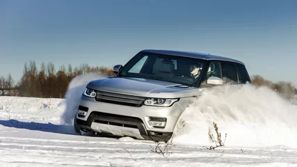 Crédence de cuisine en verre imprimé Voitures rapides Powerful 4x4 offroader car running on snow field
