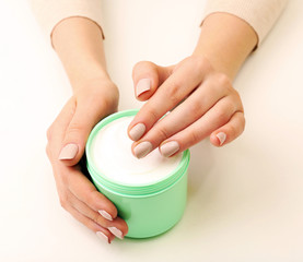 Female hands holding jar of cream isolated on white