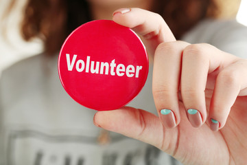 Round volunteer button in hand close-up