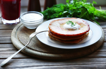 Stack of corn tortillas with stuffing, greens and cream