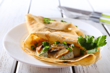 Pancakes with creamy mushrooms and greens in plate