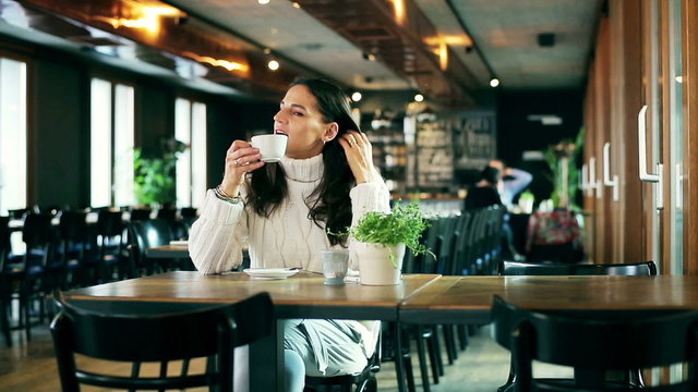 Happy woman drinking coffee in the restaurant and relaxing