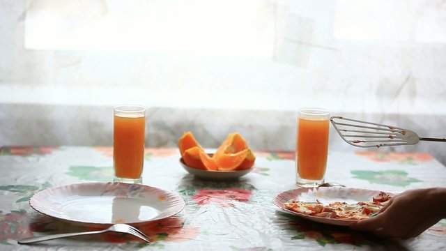 waitress lays eggs in a plate on the table. Breakfast with juice