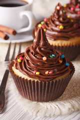 Cupcakes with chocolate cream close-up and coffee, vertical
