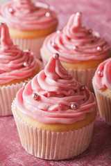 Delicate festive cupcakes with pink cream close-up, vertical