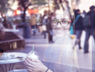 Young blonde girl drinking coffee in cafe.