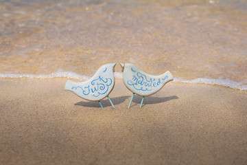 Fototapeta na wymiar handmade toy birds with wedding rings on the beach in Thailand.