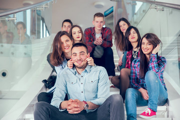 Happy teen girls and boys on the stairs school or college. Selec