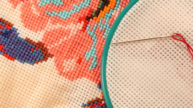 Blue hoop with thread and bright embroidery, flosses, close up