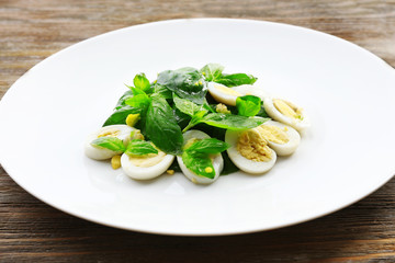 Salad with quail egg and basil in plate