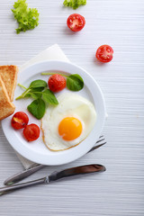 Bacon and eggs on color wooden table background
