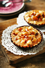 Mini cakes with nuts on wooden background