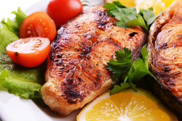 Tasty baked fish on plate close-up
