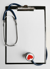 Stethoscope with tablet for notes on light background