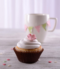 Delicious cupcake on table on light background