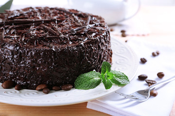 Tasty chocolate cake with mint on table close up