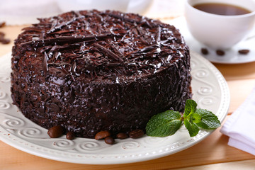 Tasty chocolate cake with cup of tea on table close up