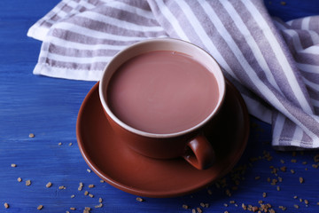 Cup of cocoa with sugar on color wooden background