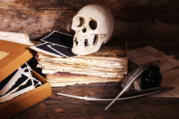Still life with human skull, retro book and quill