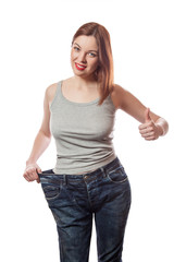 woman in big jeans showing successful weight - thumb up