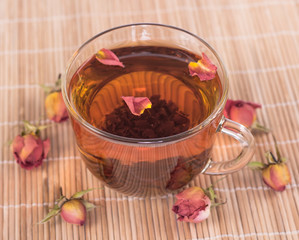 transparent cup of rose tea on wooden background