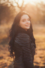 portrait of a young smiling woman at sunset in the park.
