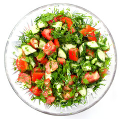 Fresh vegetable salade in a glass bowl on a white background
