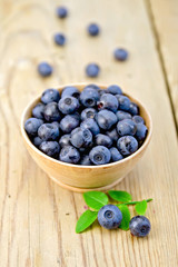Blueberries in wooden bowl on board