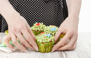Woman decorates easter cupcakes