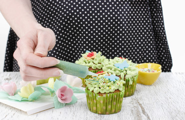 Woman decorates easter cupcakes