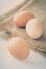 Healthy food brown chicken egg on brown fabric background