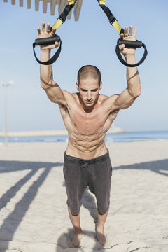 Young male athlete working out at the beach