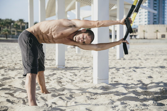 Young male athlete working out at the beach