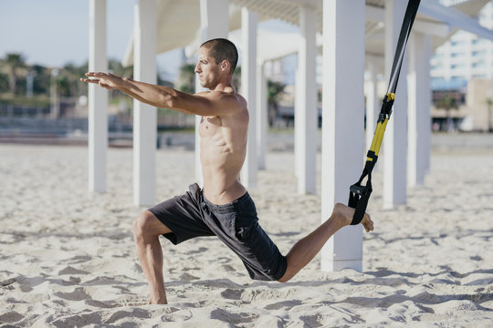 Young male athlete working out at the beach