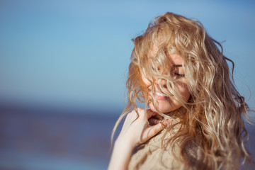 A young woman is smiling, her hair hanging down on her face