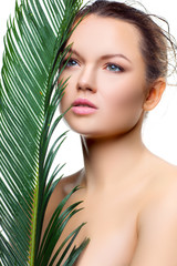 Woman with fresh tropical palm leaf. Health concept