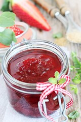 Homemade delicious strawberry jam on a rustic wooden table