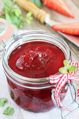 Homemade delicious strawberry jam on a rustic wooden table