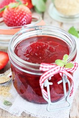 Homemade delicious strawberry jam on a rustic wooden table